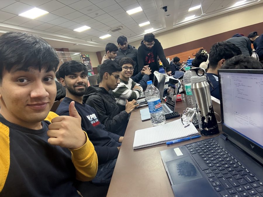 A row of students at laptops in the computer lab, code open on the nearest screen