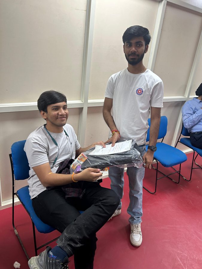 Two volunteers with a certificate and event t-shirt at the end of a college event