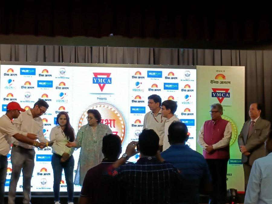 An award being presented on a sponsored stage at a YMCA and Dainik Jagran event